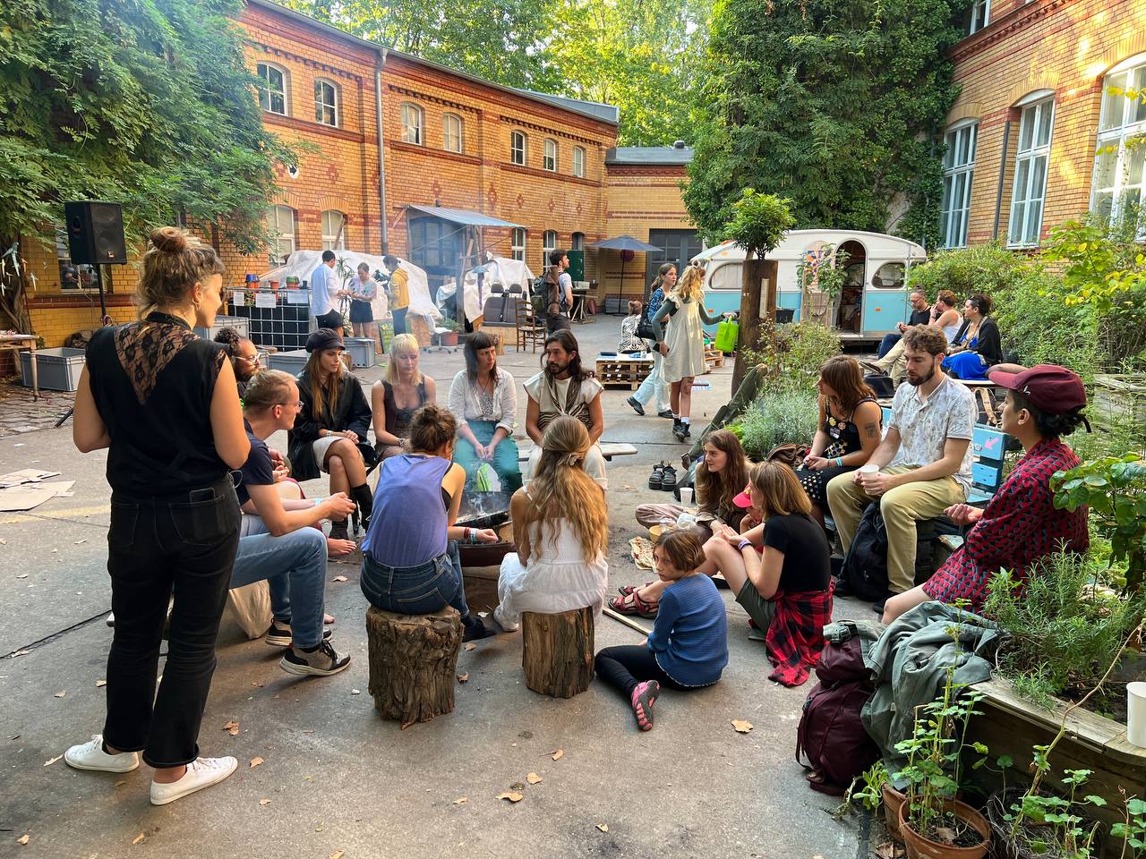 MOOS Berlin, communal gathering in the brick courtyard. Photo from the Supernuclear case study (guest post by Nicole Reese, Regen Tribe, 2023).